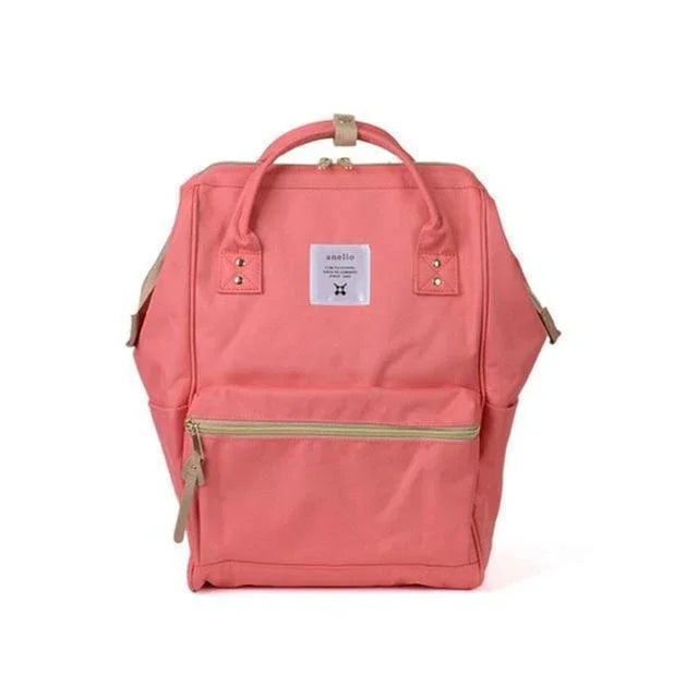 Coral pink Anello backpack with front zipper pocket and top handles on white background