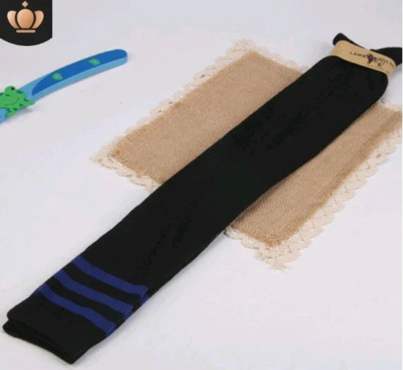 black knee-high socks with blue stripes displayed on woven beige mat