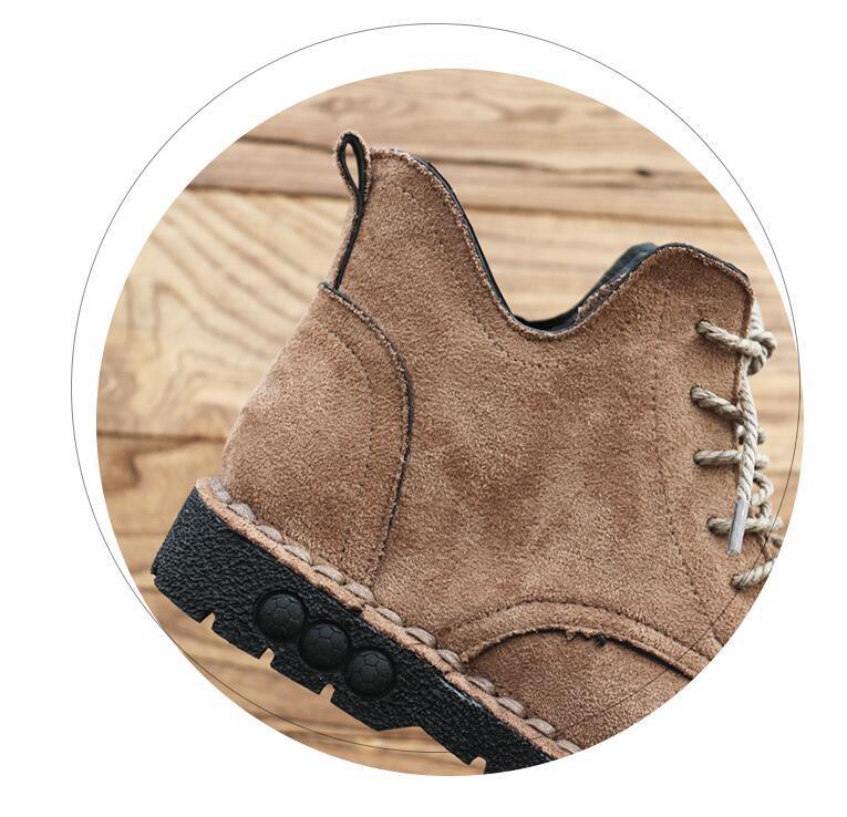 Close-up of tan suede hiking boot with black sole and rugged tread on wooden surface