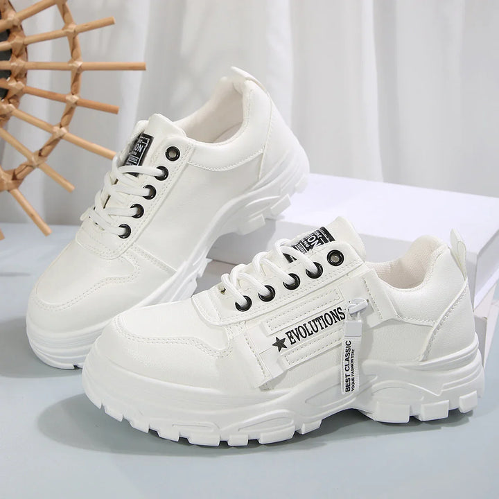 White chunky platform sneakers with black eyelets and 'EVOLUTIONS' label on side, displayed on white surface
