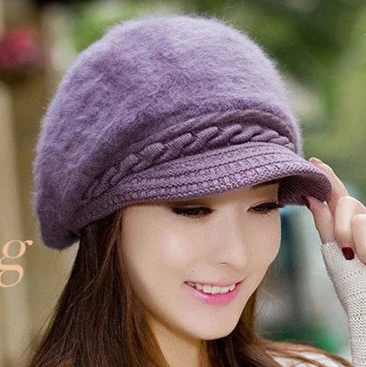 Woman wearing a soft purple knit newsboy cap with braided detail and a short brim outdoors