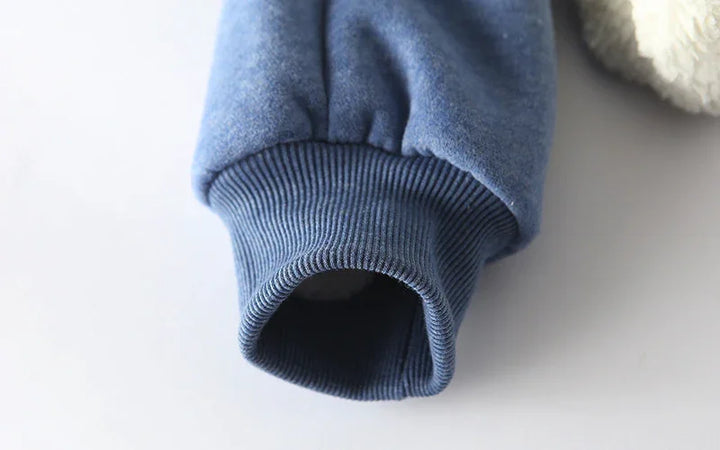 Close-up of blue fleece jacket sleeve with ribbed cuff on white background