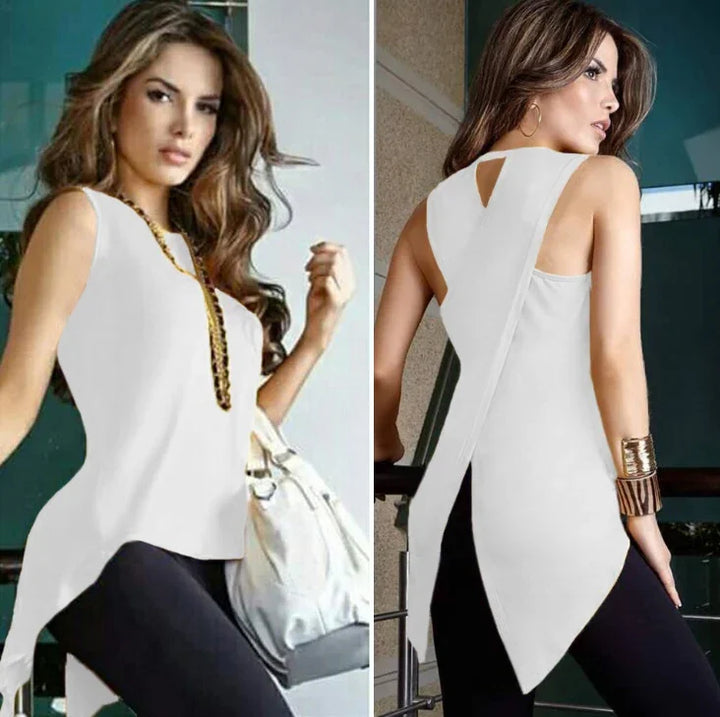 Woman modeling sleeveless white asymmetrical top with long back, paired with black pants and accessories
