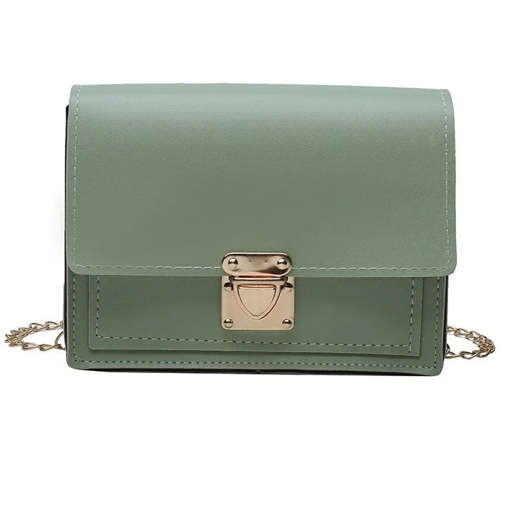 Minimalist sage green leather crossbody bag with gold chain strap and metal clasp