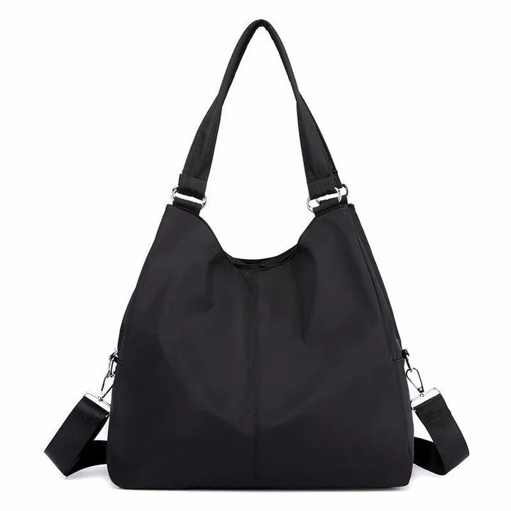 Black nylon shoulder bag with dual straps and silver hardware on a white background