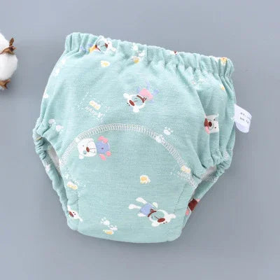 Light green baby training pants with cute animal prints on gray background
