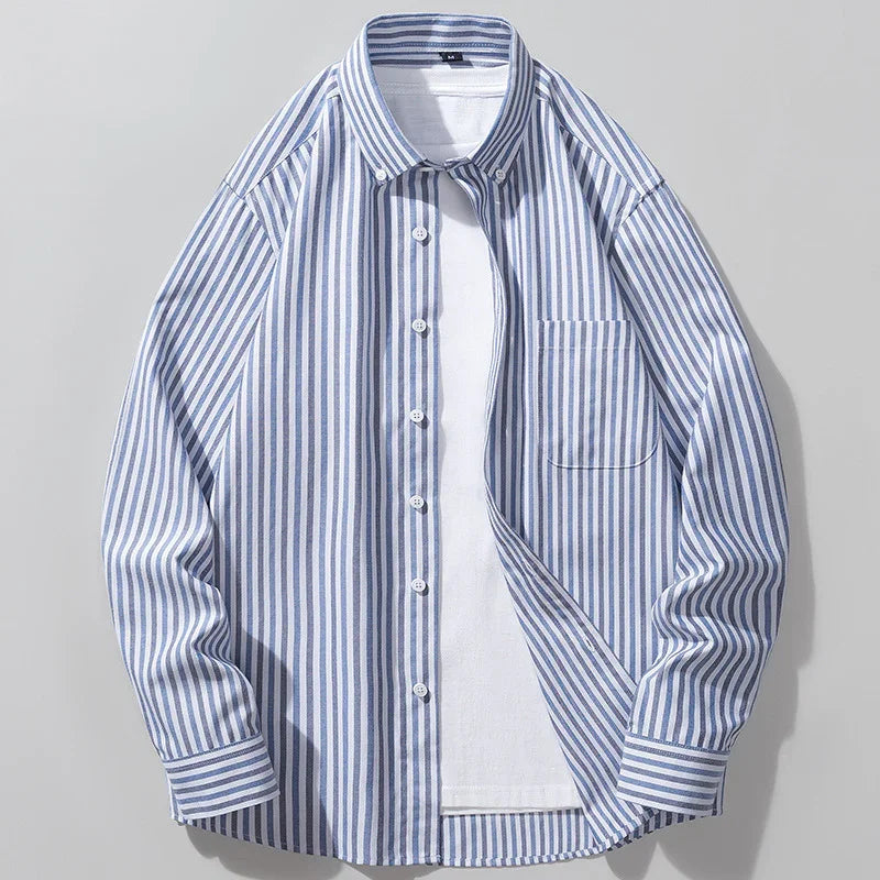 Blue and white vertical striped button-up shirt over white T-shirt on light background