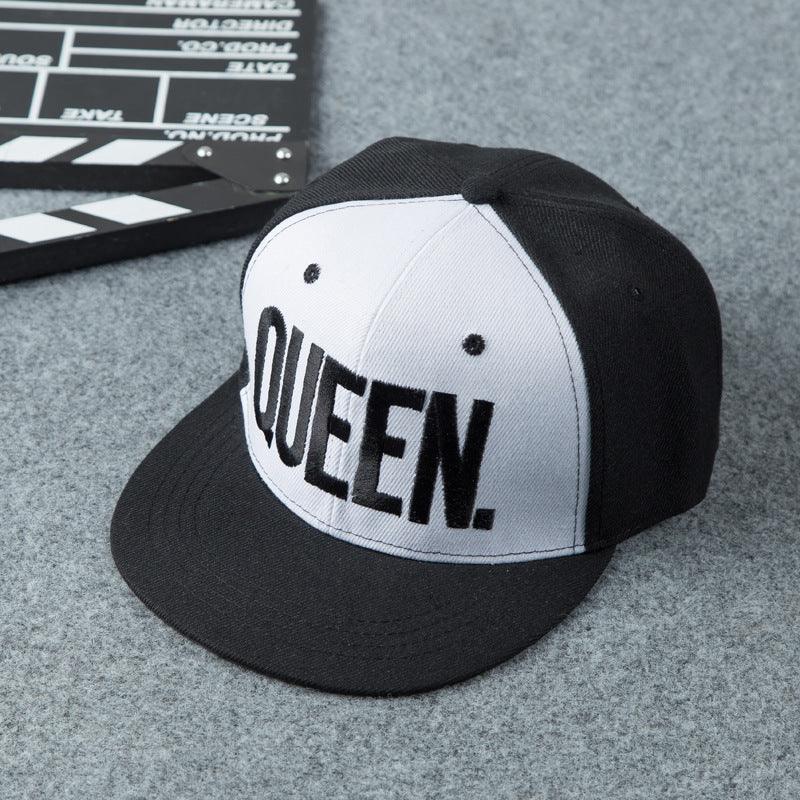 Black and white snapback cap with bold 'QUEEN.' embroidery on front panel on gray fabric