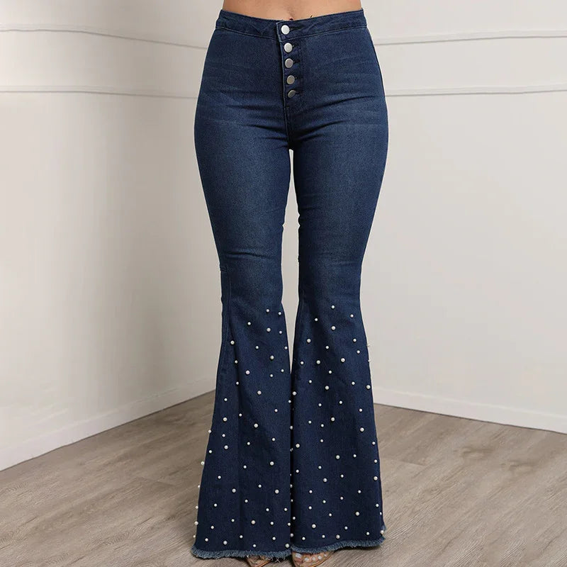 High-waisted dark blue flared jeans with silver buttons and pearl embellishments on legs