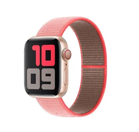 Gold Apple Watch with coral pink nylon band and digital time display in bold red and gray