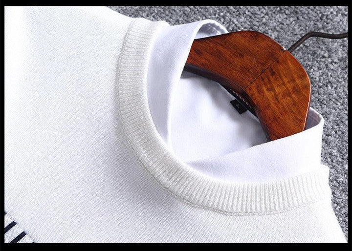 Close-up of white knit sweater with ribbed collar over white dress shirt on wooden hanger