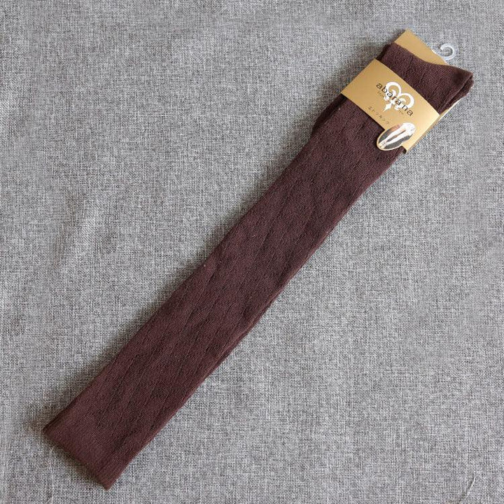 Long brown textured socks with a gold label on a gray fabric background