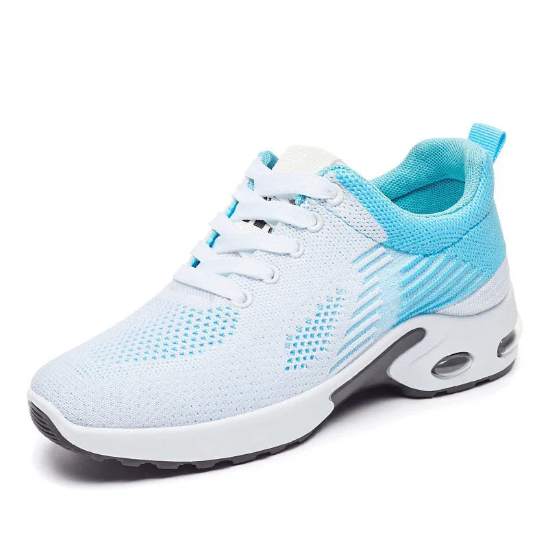 White and light blue athletic sneaker with mesh upper and thick cushioned sole on white background