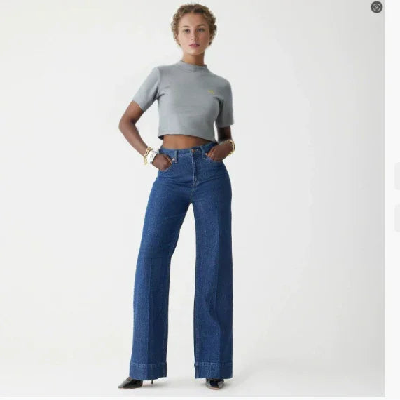 woman modeling high-waisted wide-leg blue jeans and cropped gray t-shirt in studio