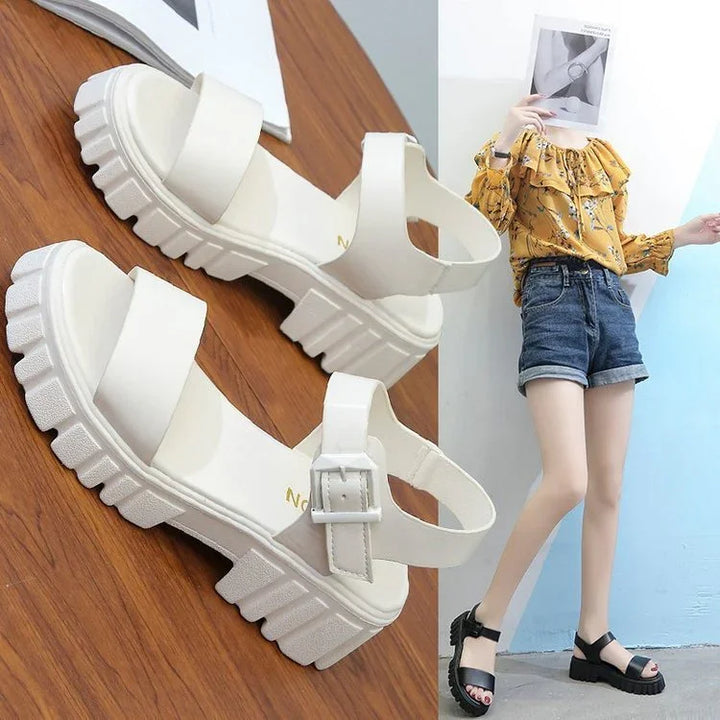 Chunky platform sandals in white and black with thick straps and buckle, styled with casual shorts and floral top