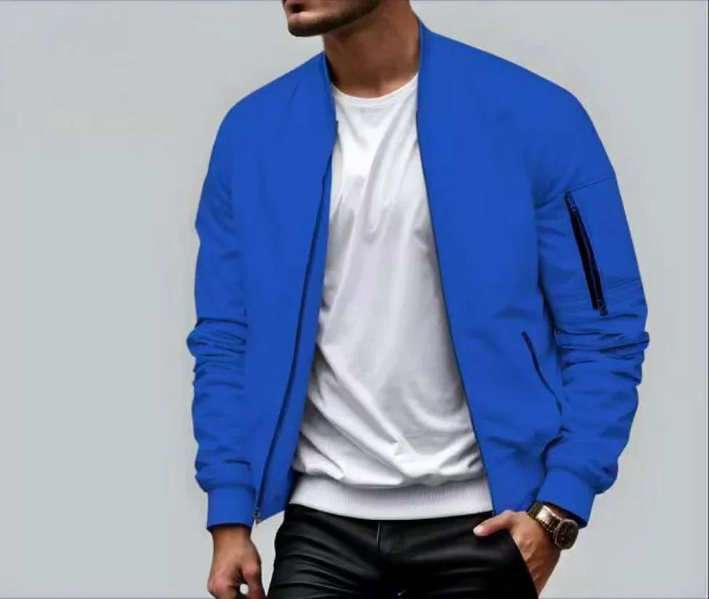 Man wearing blue bomber jacket over white t-shirt with black pants and wristwatch