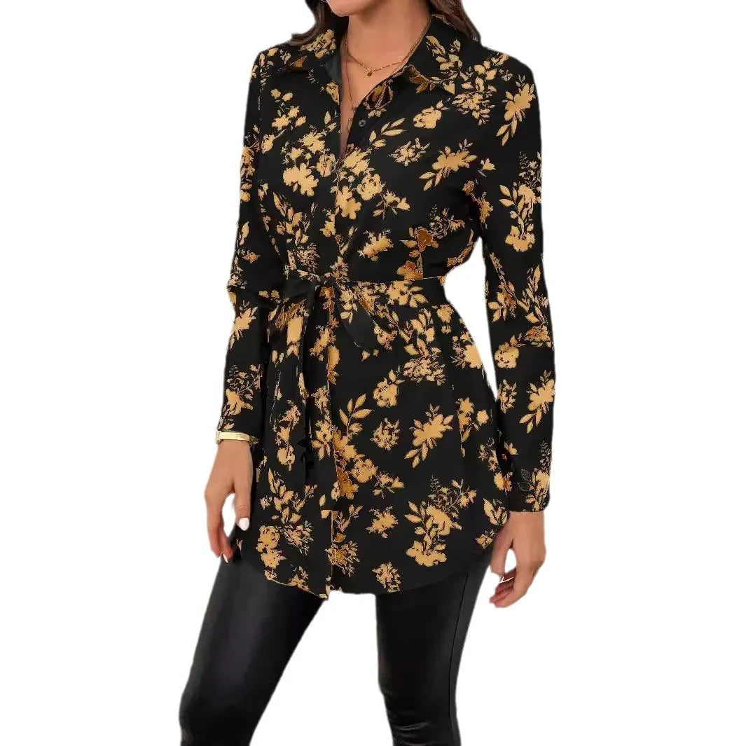 Woman wearing black long-sleeve floral print tunic blouse with a waist tie and black pants