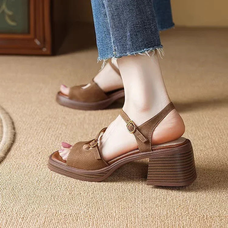 Brown leather block heel sandals with adjustable straps worn with frayed hem jeans on beige carpet