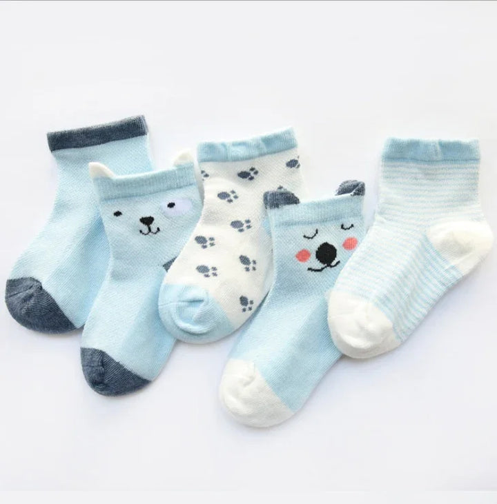 Set of five blue and white baby socks with animal faces and paw prints on a white background