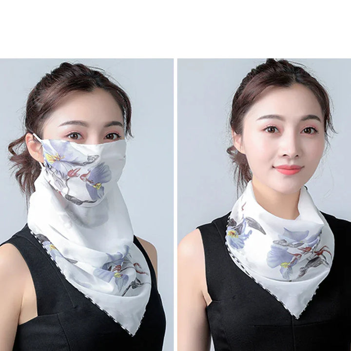 Woman wearing white floral silk scarf styled as face mask and neckerchief, black sleeveless top