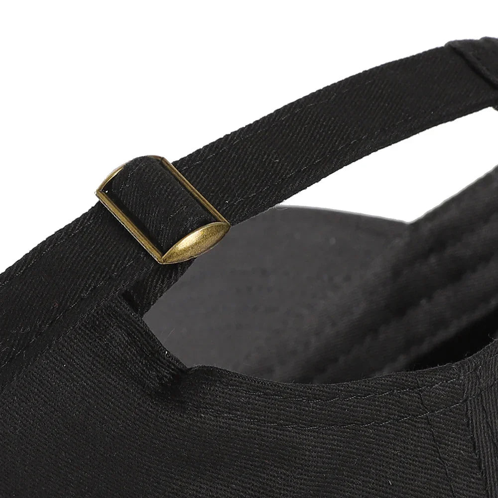 Close-up of black adjustable fabric strap with metal buckle on a black cap