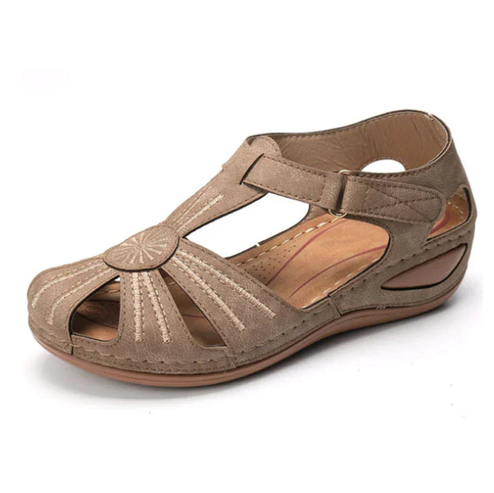 Tan closed-toe women's sandal with stitched sunburst design and adjustable ankle strap