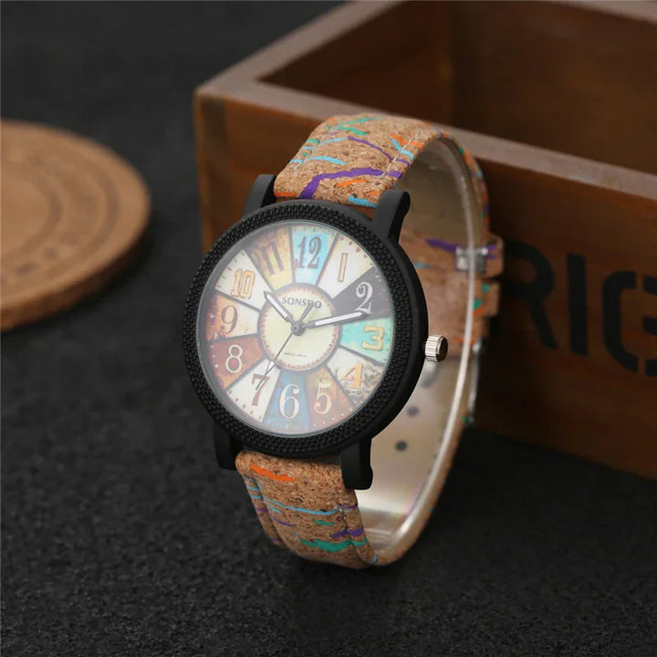 Colorful vintage-style wristwatch with multicolor numbers and patterned cork strap on black surface