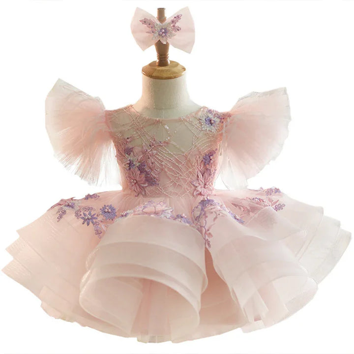 Pink toddler party dress with puff sleeves, floral embroidery, and matching hair bow