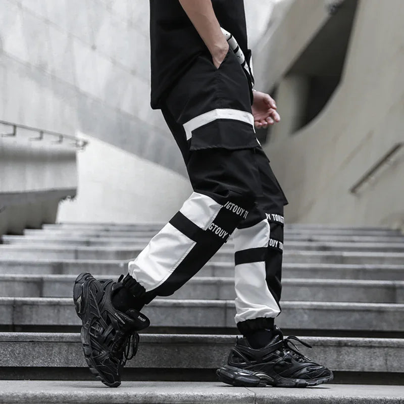 Person wearing black and white colorblock cargo pants with black sneakers walking down concrete stairs