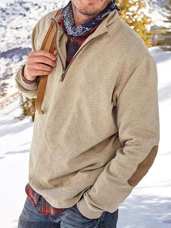 Man wearing beige quarter-zip fleece sweater with elbow patches and bandana in snowy outdoor setting