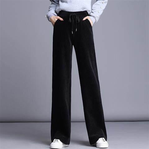 Model wearing black wide-leg velvet pants with drawstring waist and white sneakers