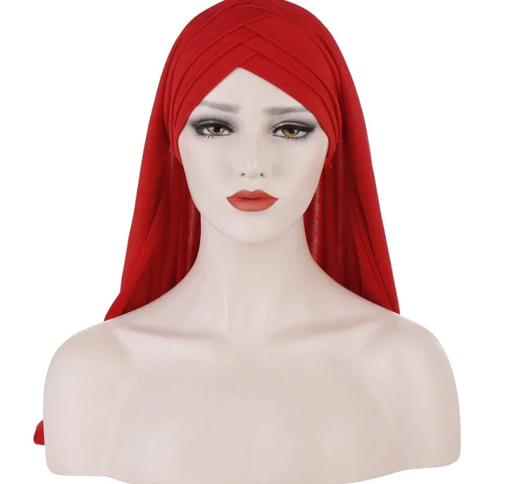 Mannequin head wearing a red turban-style hijab with makeup, isolated on white background