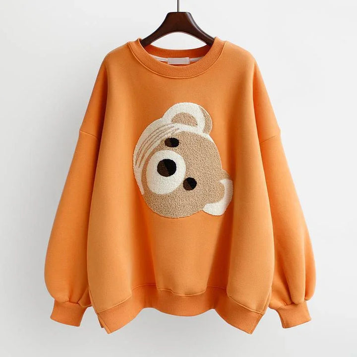 Orange oversized sweatshirt with a textured teddy bear face design on front