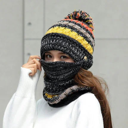 Person wearing multicolored knit beanie with pom-pom and matching neck gaiter over face
