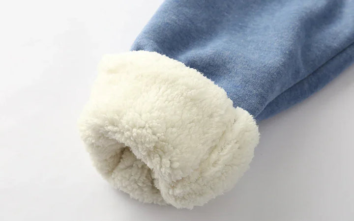 Close-up of a blue denim sleeve with a rolled-up white fleece lining for warmth