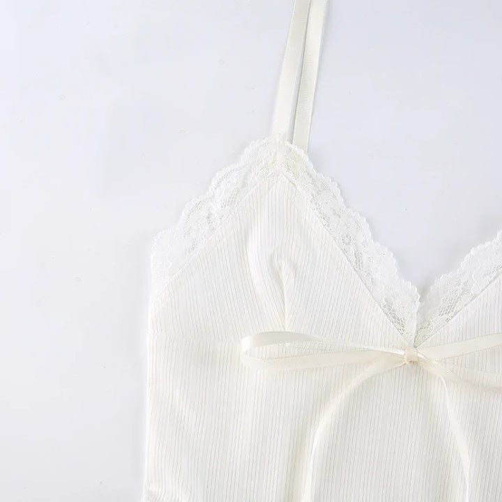Close-up of white ribbed camisole with lace trim and bow detail on spaghetti straps