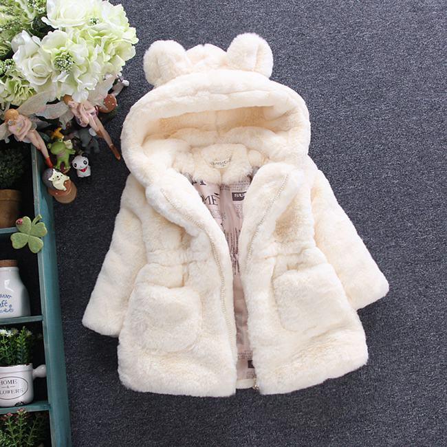 Cream-colored plush toddler coat with bear ears on hood and front pockets on gray background