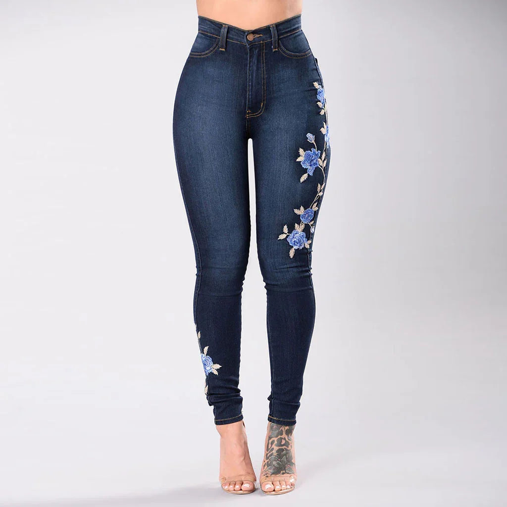 High-waisted dark blue skinny jeans with blue floral embroidery on side and ankle