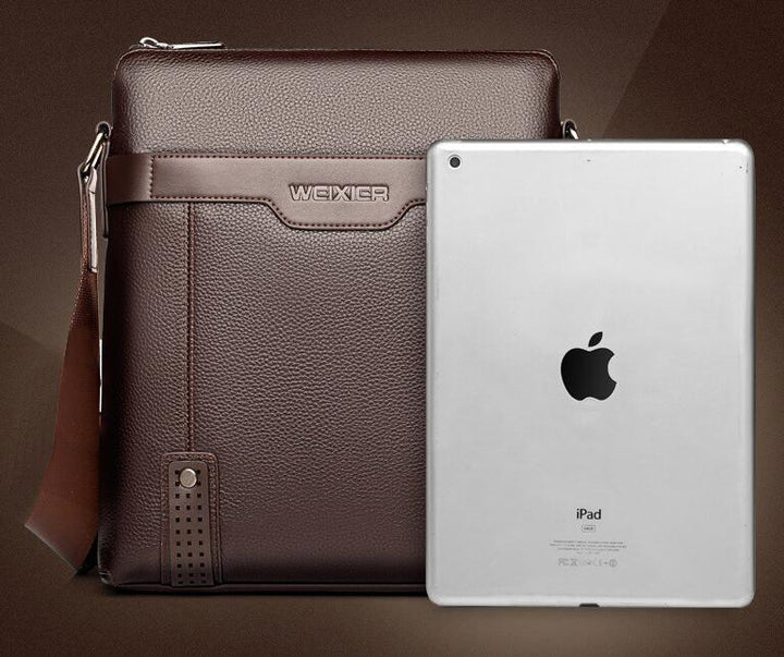 Brown leather WEIXIER shoulder bag next to silver Apple iPad tablet on brown background