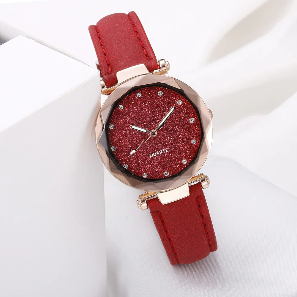 Red glitter dial quartz wristwatch with crystal hour markers and red leather strap on white background