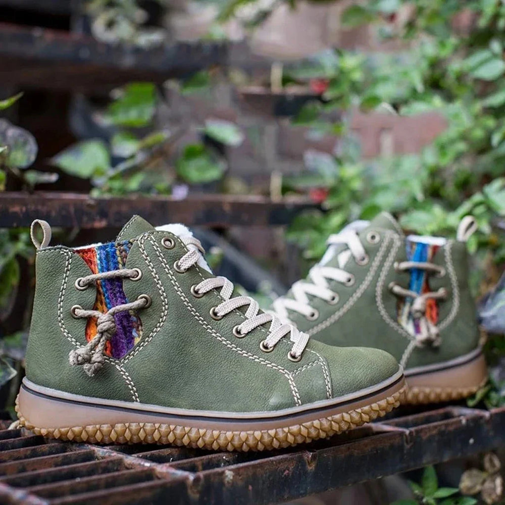 Green high-top casual boots with white laces and colorful woven accents on a metal grate outdoors