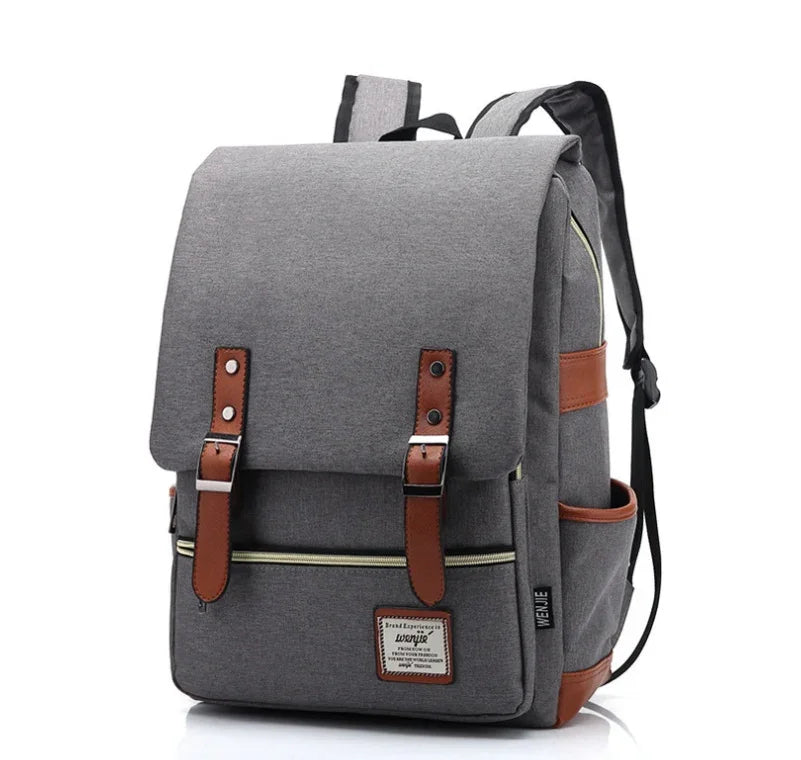 Gray canvas backpack with brown leather straps and front zip pocket, modern casual design