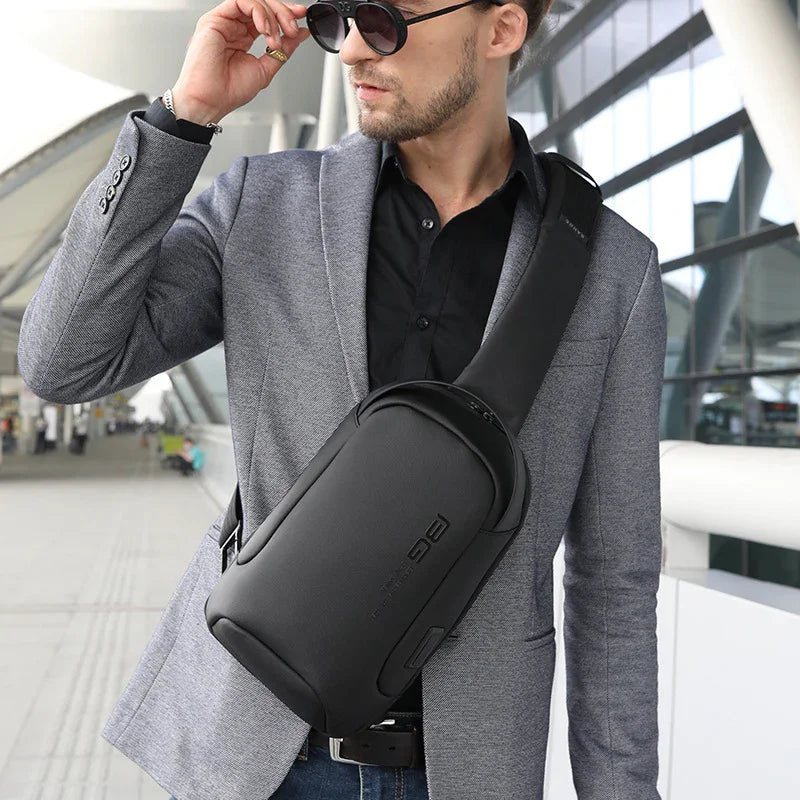 Stylish man in gray blazer wearing black sling backpack and sunglasses in modern urban setting