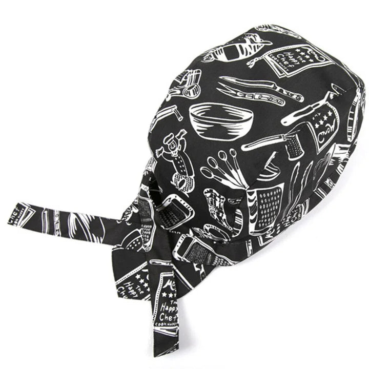 Black chef bandana with white kitchen utensils print including graters, bowls, and measuring spoons