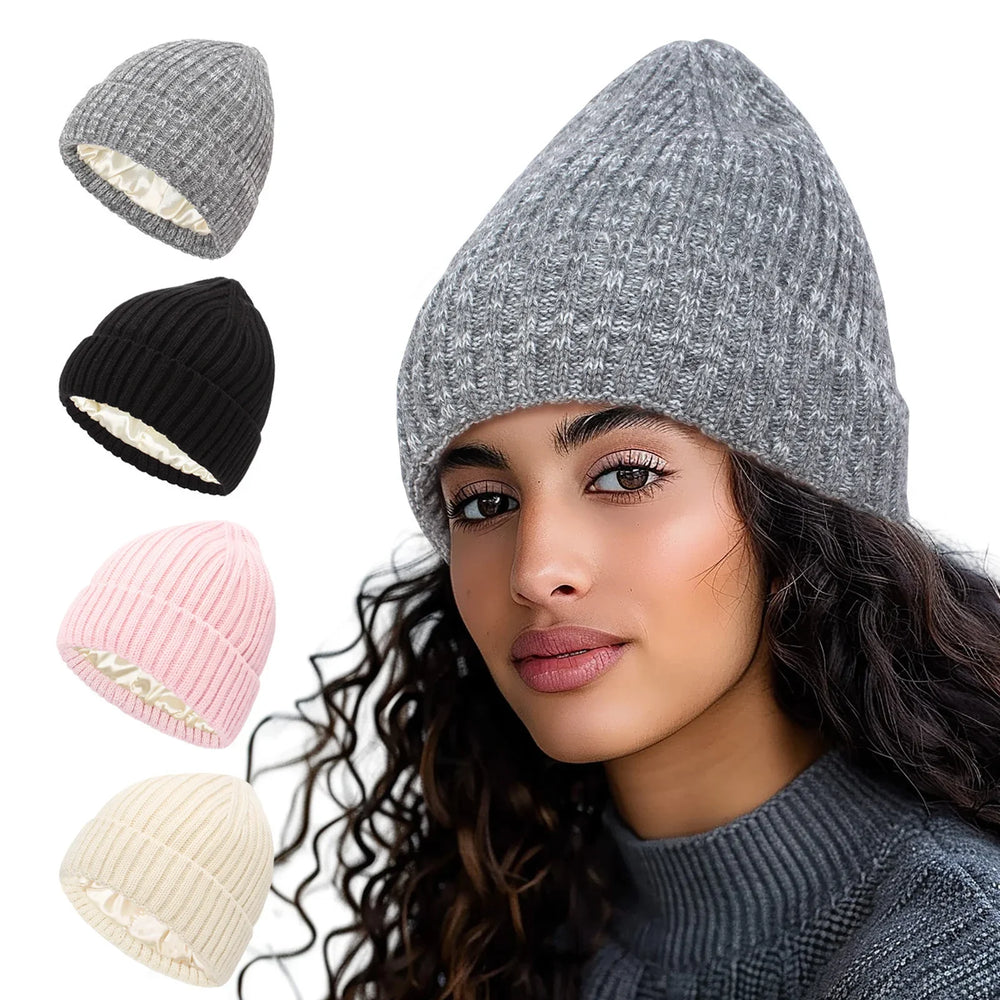 Woman wearing a gray knit beanie hat with additional pink, black, cream, and gray beanies shown