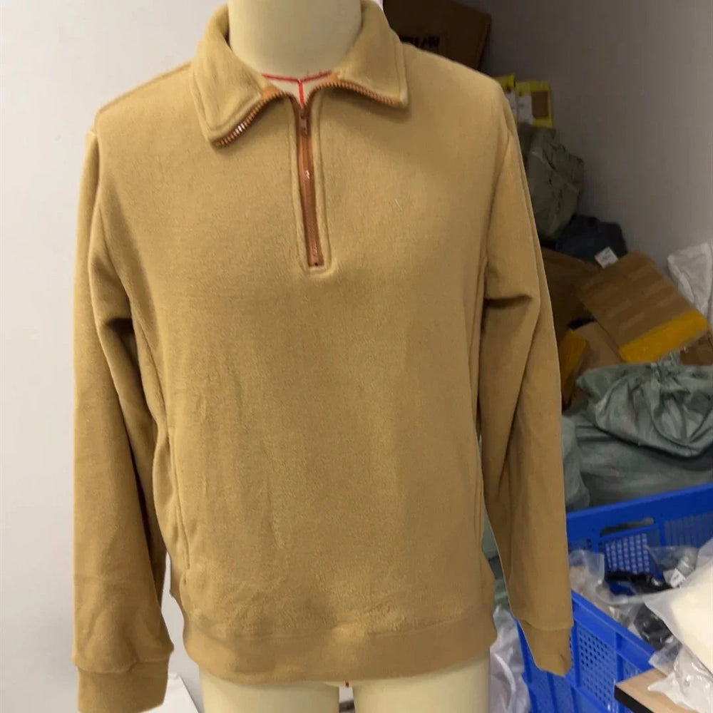 Beige fleece pullover with quarter zipper on mannequin in storage room