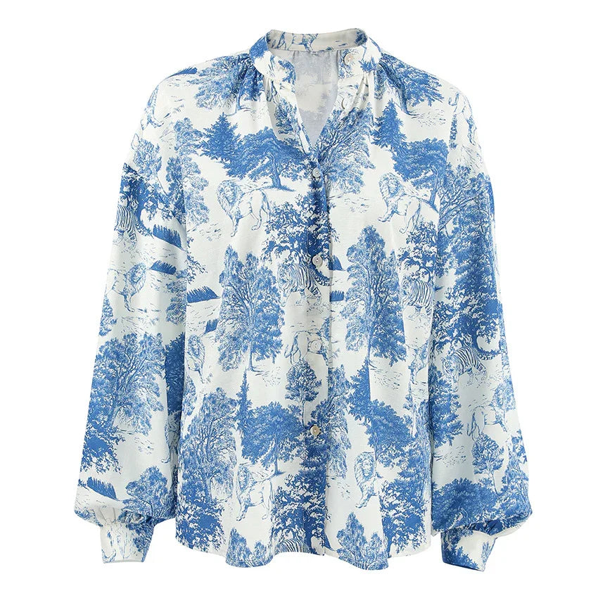 White button-up blouse with blue jungle print featuring trees, lions, and zebras