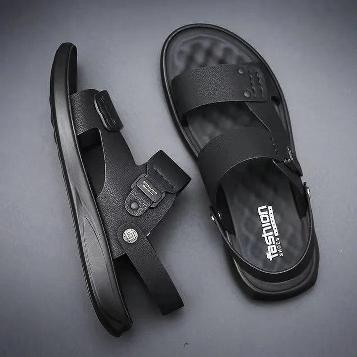 Black men's fashion sandals with adjustable straps and textured footbed on gray background