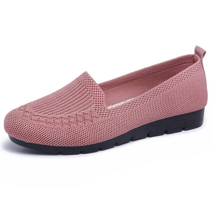Pink knit women's slip-on shoe with black sole and textured fabric upper