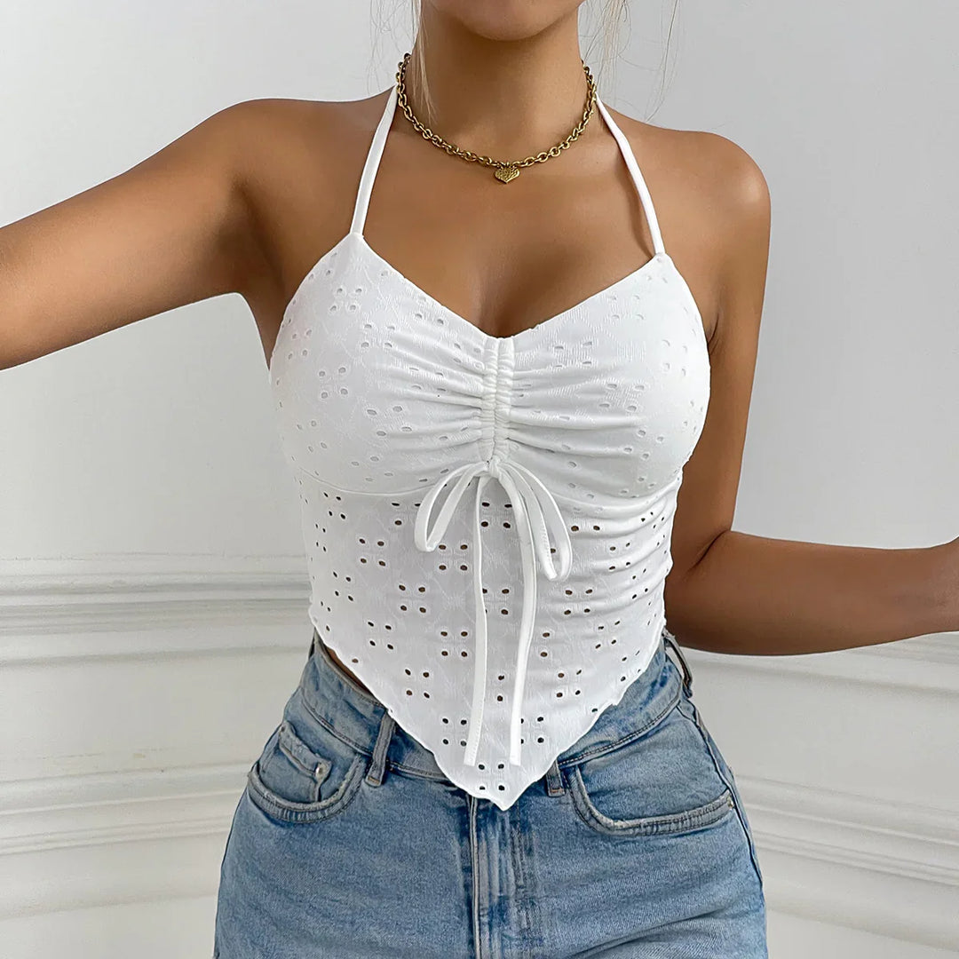 Woman wearing white eyelet halter crop top with ruched front and light blue high-waisted jeans